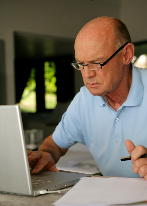 Older man working on his laptop; Revocable vs. Irrevocable Trusts: What You Should Know