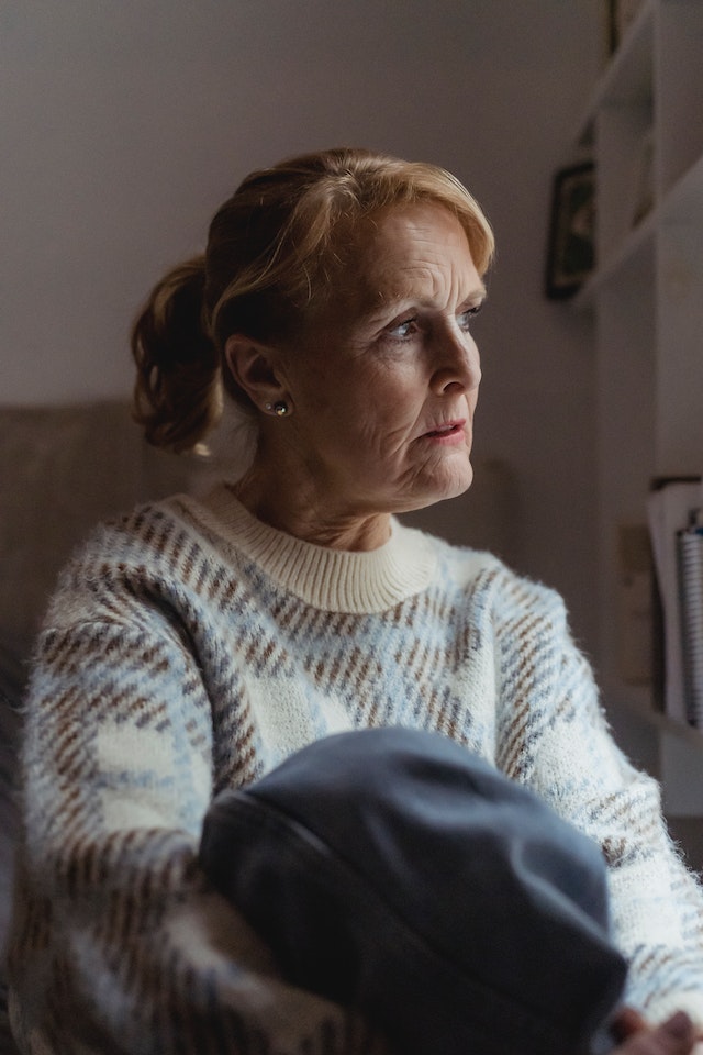 avoid probate, image of senior woman pensively gazing while seated indoors